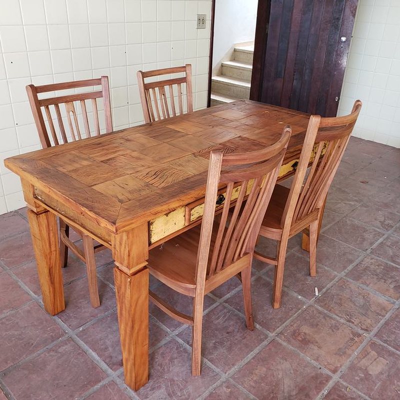 Mesa de jantar de madeira maciça com cadeiras em volta